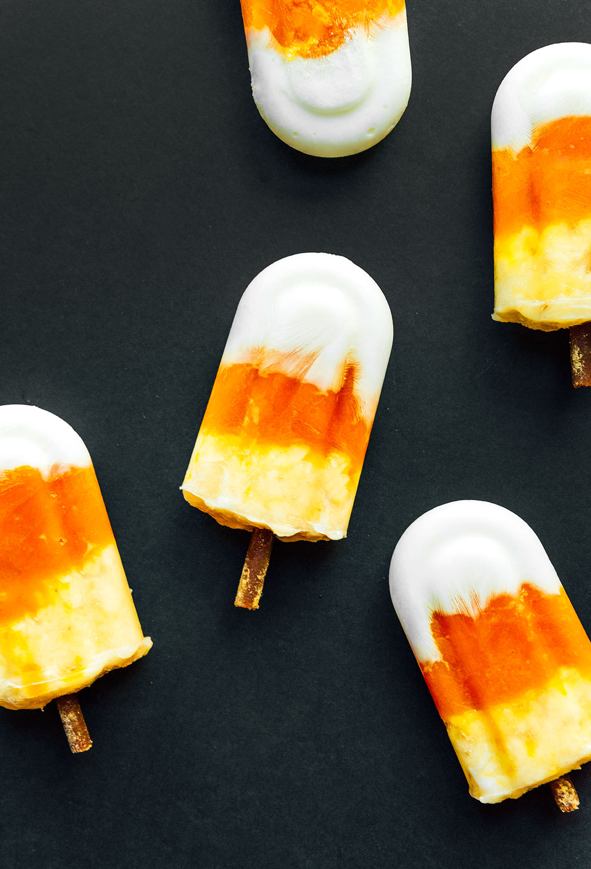 Dog popsicles that look like candy corn with treats for sticks