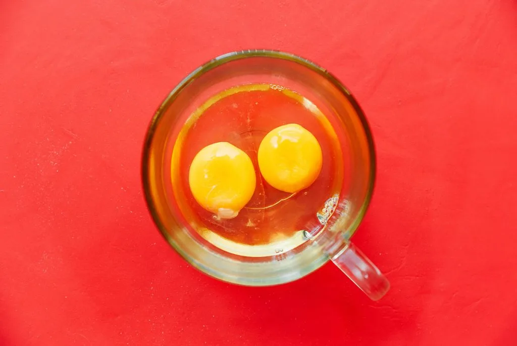 2 cracked eggs in a pyrex glass