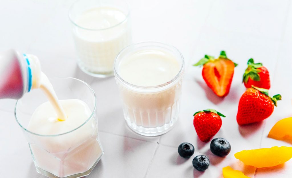 A glass of kefir with fruit next to it