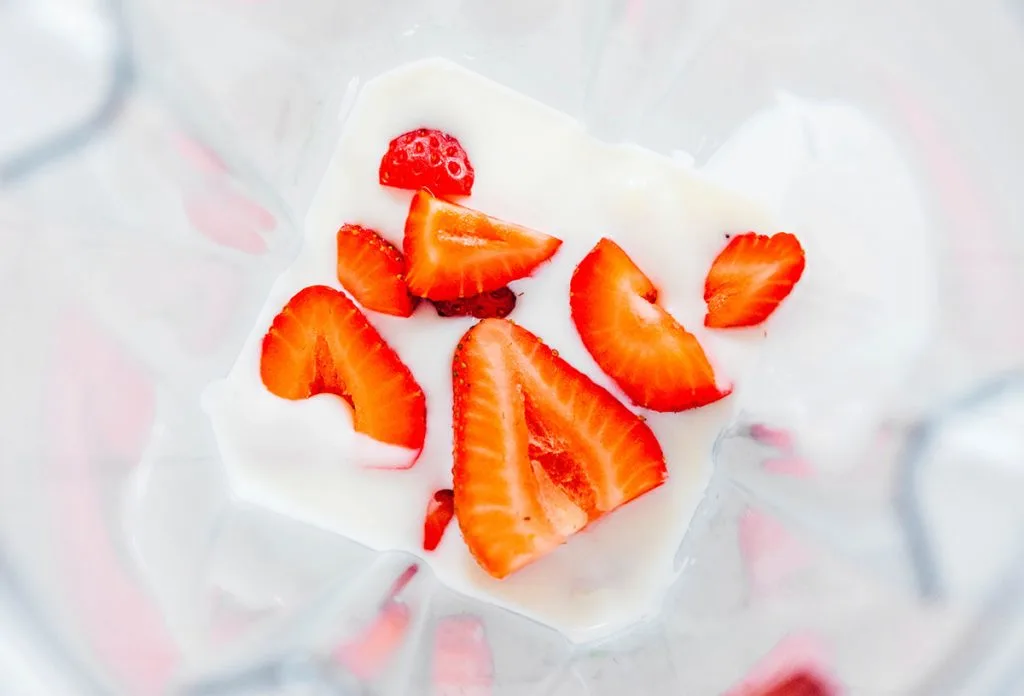 A blender with kefir and strawberries