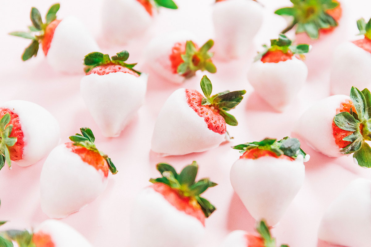 Yogurt dipped strawberries on a pink background