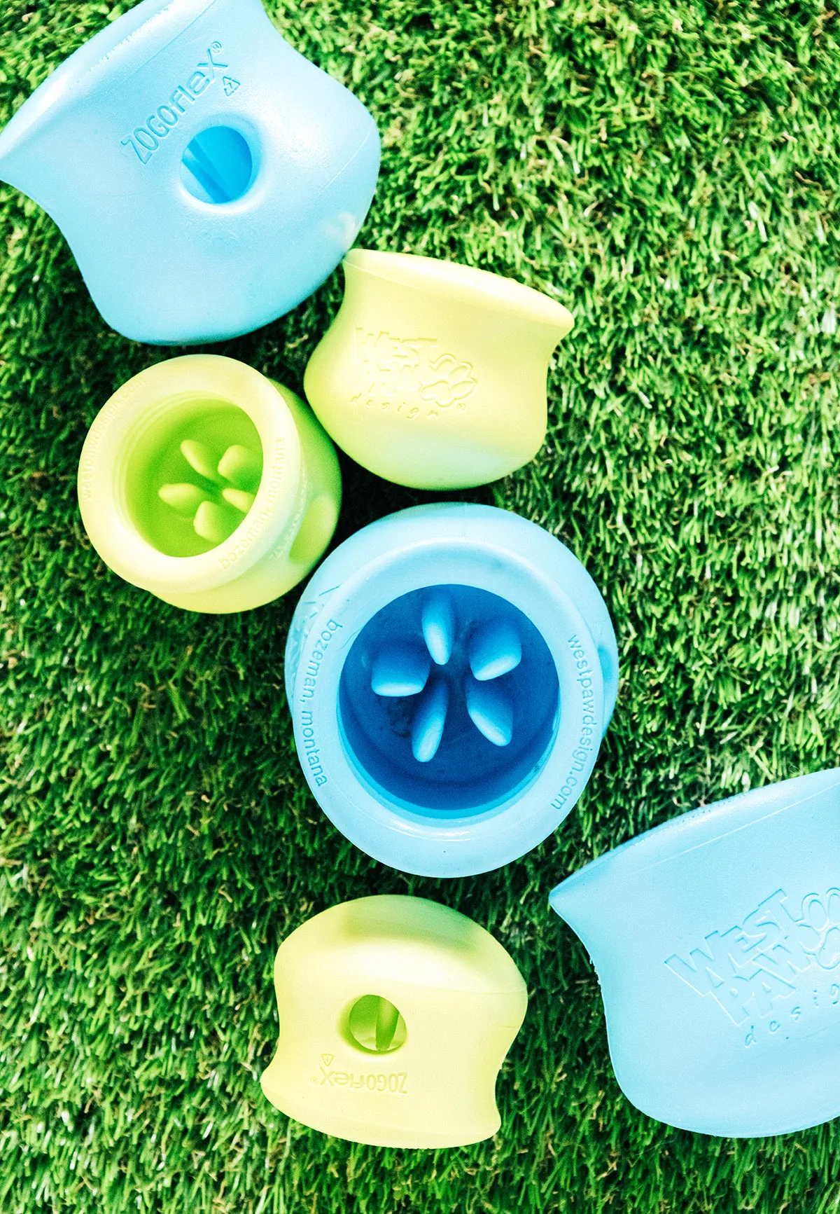 Blue and green toppls in small and large sizes laying on grass.