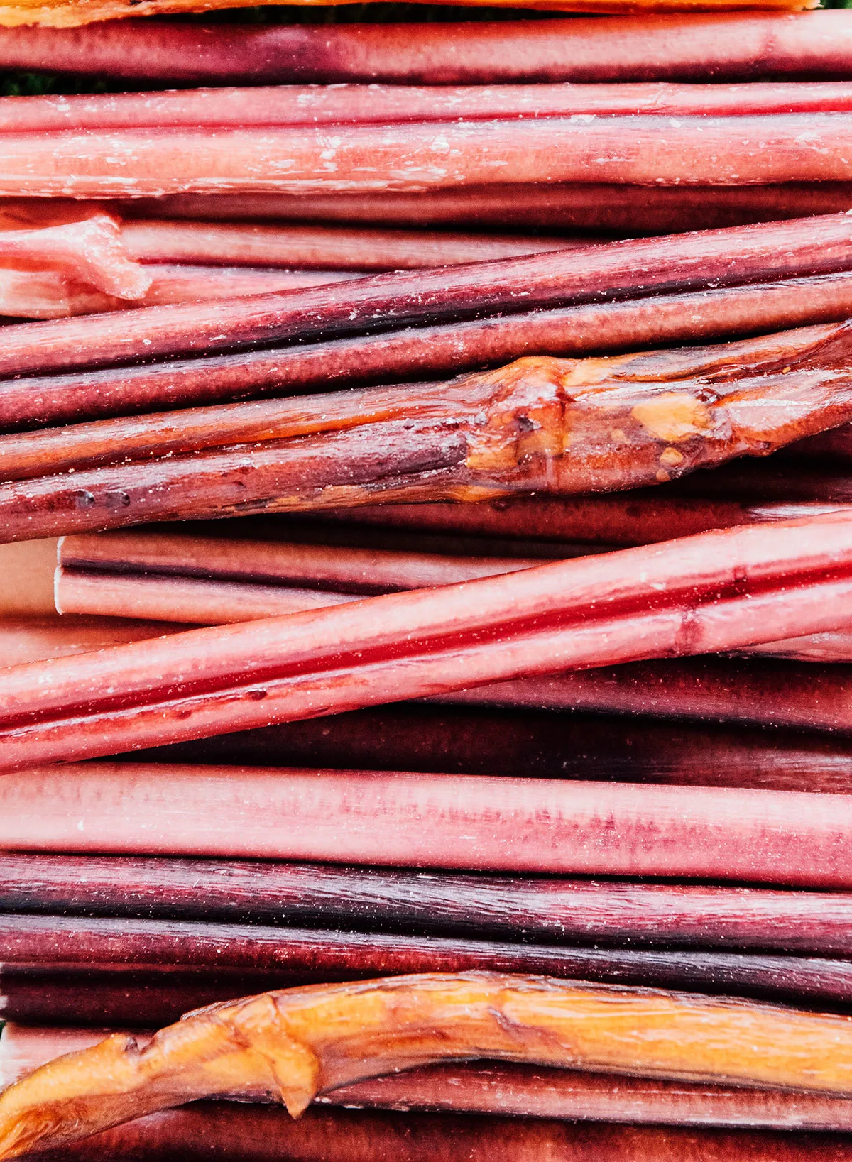Up close image of bully sticks that are reddish brown in color and resemble sticks.