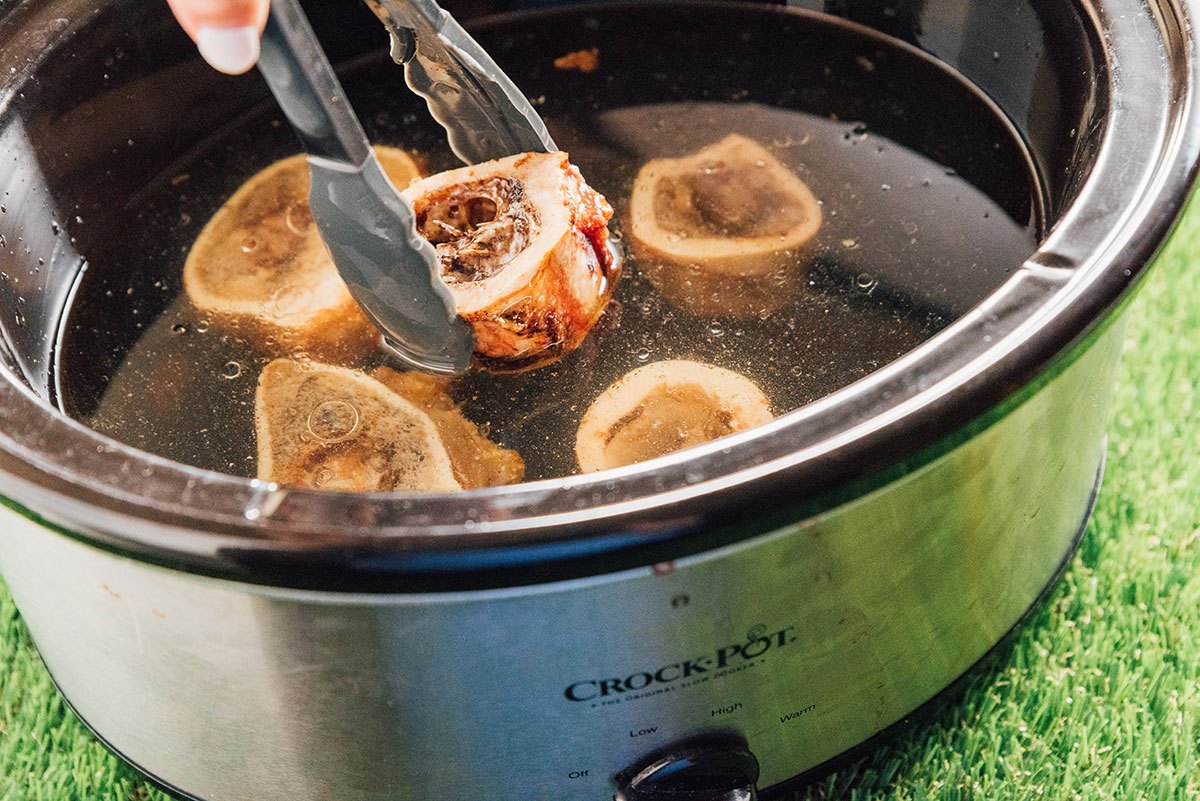 Putting roasted marrow bones in a slow cooker