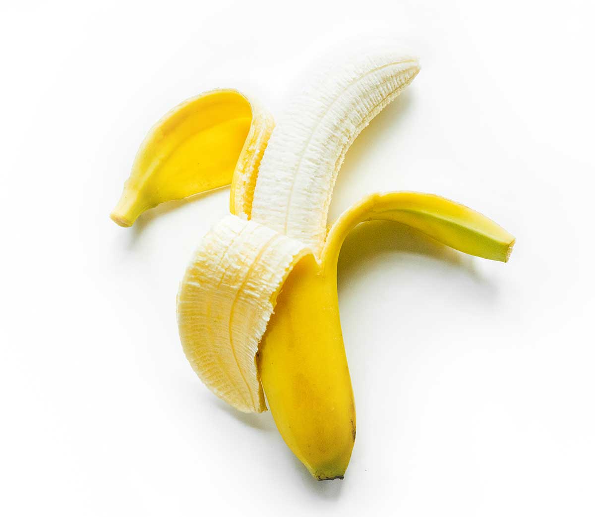 Half peeled banana on white background