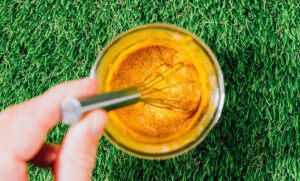 Whisking golden paste in a jar.
