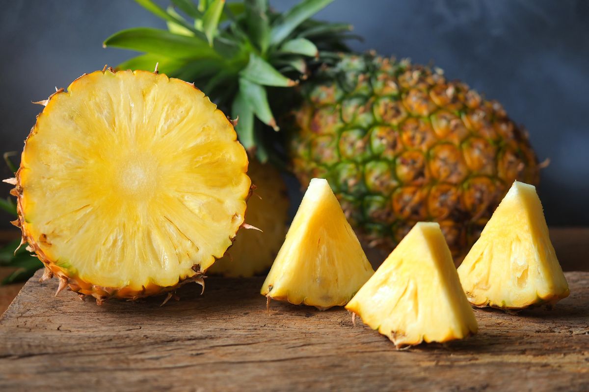 Pineapple cut open on a wood board.