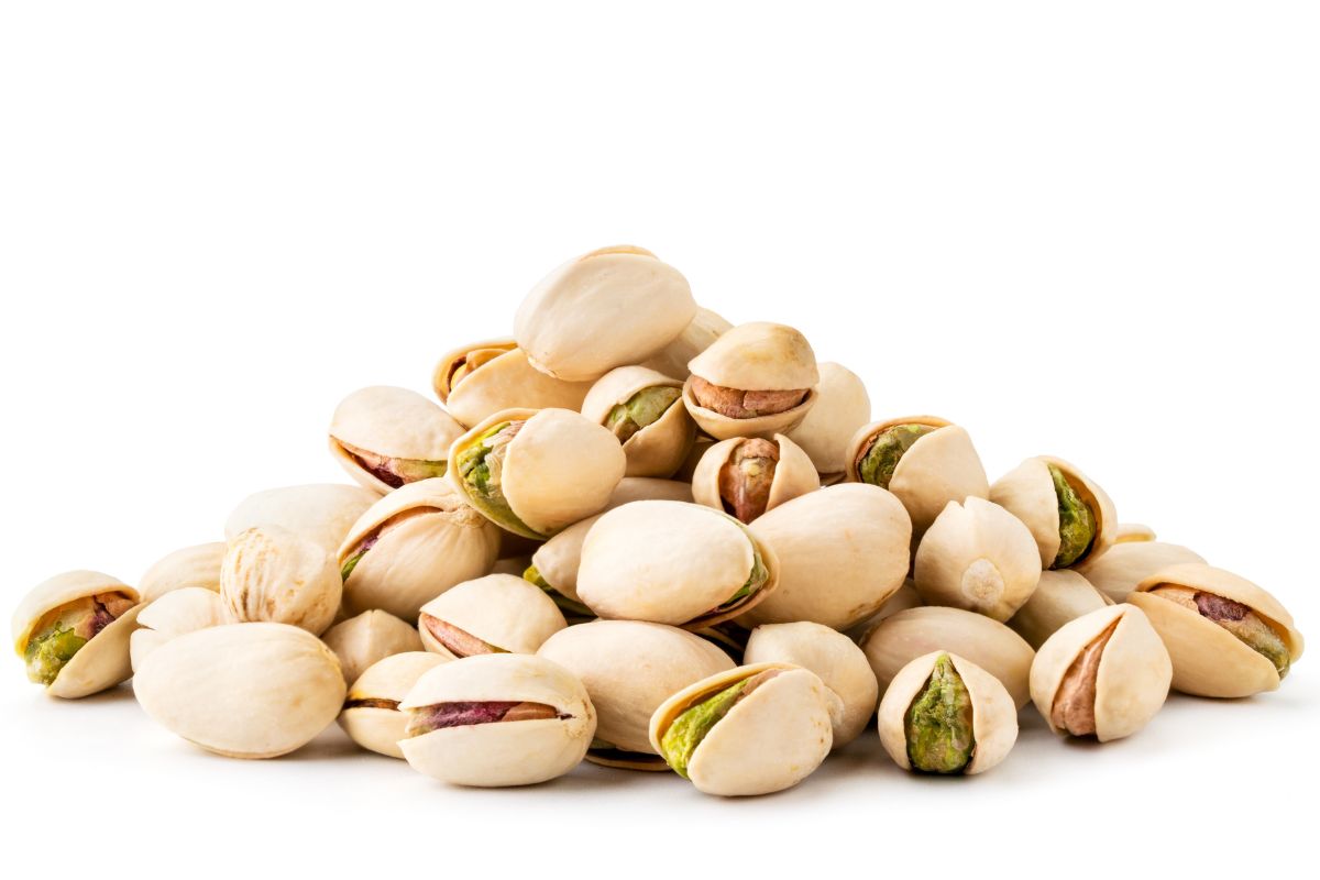 A pile of pistachios with shells on it.