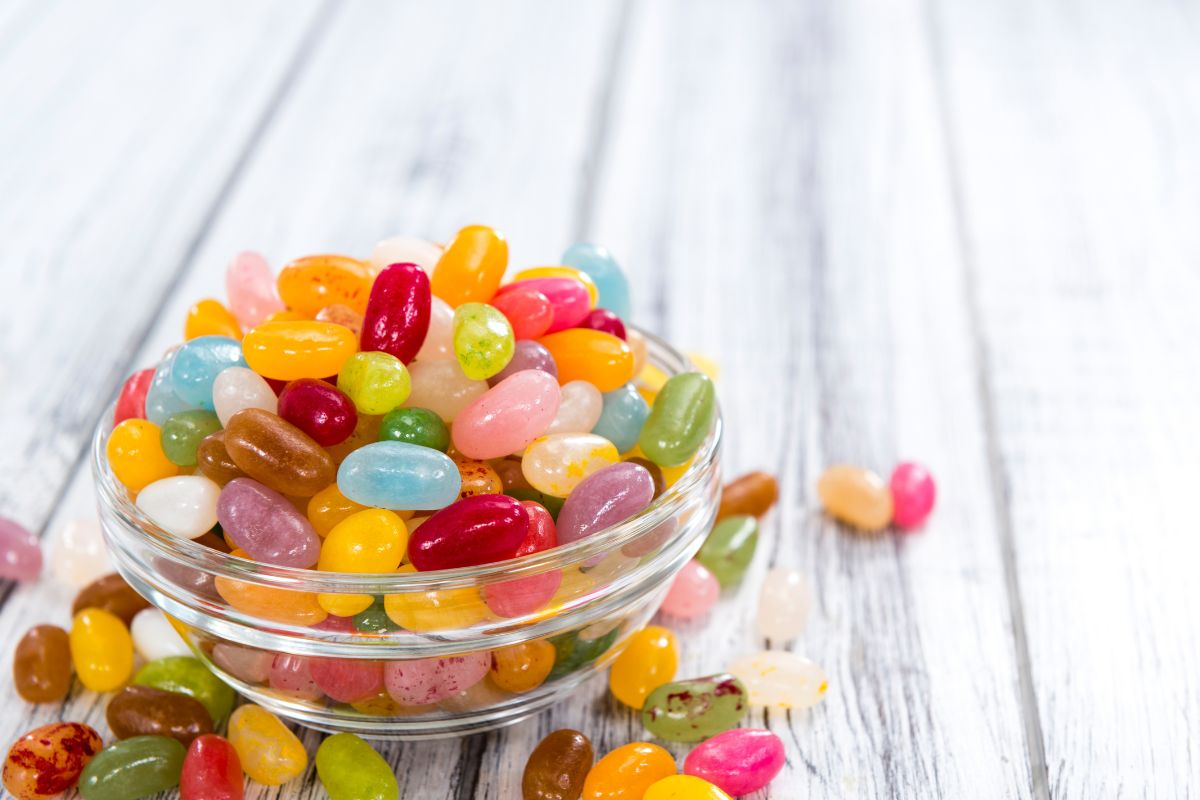 A bowl of jelly beans on a white table.