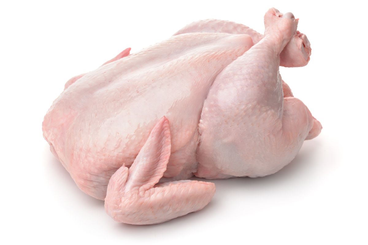 A whole raw chicken on a white background.