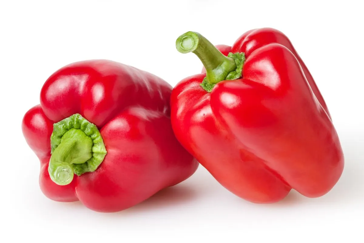 Two red bell peppers on a white background.