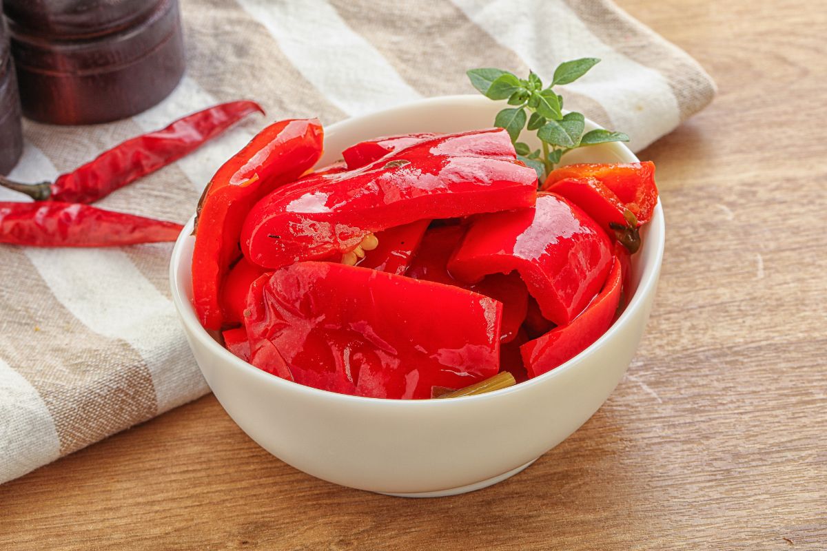 Sliced red bell peppers in a white bowl.