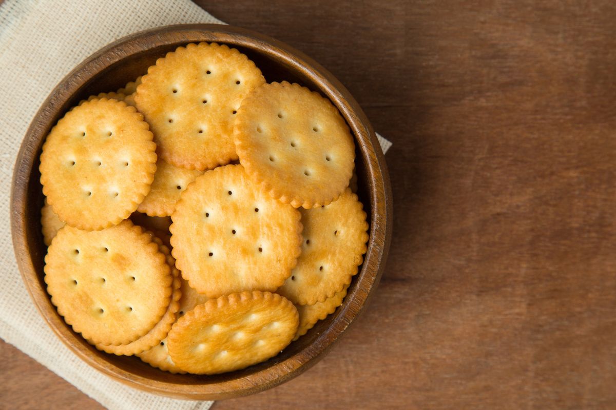 Ritz crackers in a bowl on a wood table.